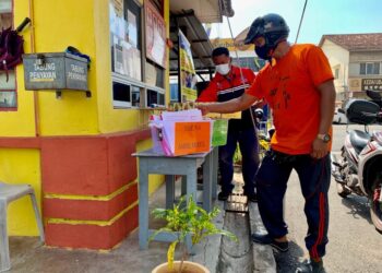 Ibu bapa mengambil lembaran kerja di pondok pengawal SK Kuala Perlis bagi membolehkan anak-anak mereka terus belajar walaupun sekolah ditutup ekoran  PKPB.