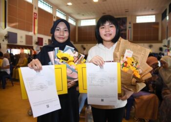 NUR Hawa Balqis Mohamad Ros (kiri) dan Pang Joe Wen dari kawasan perkampungan nelayan Kuala Perlis menunjukkan keputusan cemerlang dengan memperolehi masing-masing 8A dan 9A dalam SPM di SMK Kuala Perlis. - UTUSAN/IZLIZAN OTHMAN