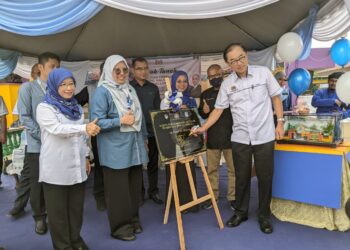 MAH Hang Soon (kanan) menandatangani plak sebagai simbolik majlis pecah tanah pembinaan dewan terbuka SK Tanjong Malim di Tanjung Malim hari ini. - UTUSAN/MOHAMAD HAFIZI MOHD SAID