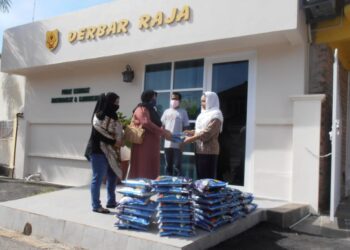 SISKA Jona (kanan) menyerahkan sumbangan beras kepada wakil penduduk Kampung Baru Pulau Tiga, Sungai Layar, Jalan Lencongan Barat di Bandar Laguna Merbok di Sungai Petani hari ini. - UTUSAN/OTHMAN YAHAYA