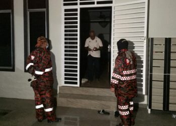 ROZIZAH Abni Hajar (kanan) memujuk penduduk meninggalkan kediaman di Kampung Beladau Selat di Kuala Terengganu, malam tadi. - TENGKU DANISH BAHRI TENGKU YUSOFF