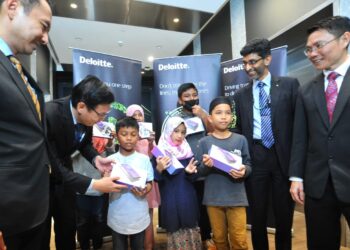 EE Ting Han (dua dari kiri) beramah mesra dengan enam orang kanak-kanak yang menerima tablet sempena perasmian Cawangan Deloitte Malaysia di Menara Jland, Johor Bahru di sini. UTUSAN/RAJA JAAFAR ALI