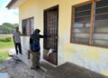 Bahari Man (kiri) dan Hamiah Osman (kanan) 
meninjau keadaan rumah adiknya yang terletak bersebelahan kediamannya di Kampung Lat 1000, Simpang Empat, Perlis semalam. - UTUSAN/ASYRAF MUHAMMAD