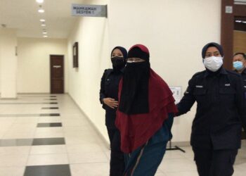 KHAIRULIZAWATI Ruslan dibawa keluar dari kamar mahkamah selepas menghadapi pertuduhan mencederakan dua kanak-kanak yang merupakan penghuni taskanya di Mahkamah Sesyen Muar, Johor. - UTUSAN/NUR ALINA HASSAN