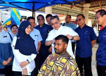 SALAHUDDIN AYUB menggunting rambut seorang pelajar secara percuma  sempena Program Usahawan Muda 2023 Peringkat Negeri Johor di Politeknik Ibrahim Sultan, Pasir Gudang. -UTUSAN/RAJA JAAFAR ALI