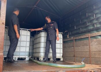 ANGGOTA penguatkuasa KPDNHEP Pahang menunjukkan tangki petak yang diubah suai berkapasiti 1,000 liter diletakkan di atas lori tujuh tan untuk diisi minyak diesel sebelum dijual ke luar negeri Pahang di Indera Mahkota, Kuantan, Pahang. - UTUSAN/ DIANA SURYA ABD WAHAB