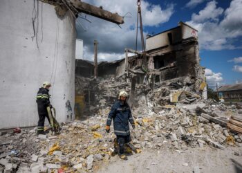 ANGGOTA bomba membersihkan serpihan konkrit yang musnah di bangunan kebudayaan di Derhachi, Kharkiv.-AFP