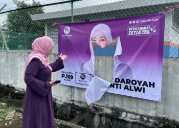 DR. Daroyah Alwi menunjukkan salah satu poster kempennya dikoyak di Jalan Dato' Tahir Manan, Klang, Selangor. -UTUSAN/ MOHAMAD NAUFAL MOHAMAD IDRIS
