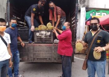 MOHD. Shukri Omcek (kanan) bersama rakan-rakannya menurunkan buah durian yang dijual pada harga RM1.99 di Pesiaran Raja Syed Thauphy 4,  Bagan Serai, Perak, semalam. - FOTO/WAT KAMAL ABAS