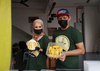 DURIAN musang king dari Raub yang dijual Mohamad Hakim Fahmi Awang (kanan) turut menjadi pilihan Sultanah Terengganu, Sultanah Nur Zahirah ketika ditemui di kedainya di Ladang, Kuala Terengganu, hari ini.