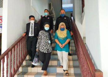 ELENITA Maisog (depan, kanan) diiring keluar penguatkuasa JPN selepas mengaku bersalah Mahkamah Majistret, Ayer Keroh, Melaka menggunakan kad pengenalan palsu sejak 21 tahun lalu. - UTUSAN/DIYANATUL ATIQAH ZAKARYA