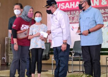 NOH Omar (dua kanan) bersama Megat Zulkarnain Omardin menyampaikan bantuan persekolahan kepada murid di Johor Bahru, Johor.