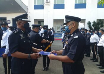 BAHARUDIN Mat Taib (kiri) menyerahkan surat penghargaan kepada anggota polis pada majlis Sambutan Peringatan Hari Polis ke-215 di perkarangan Ibu Pejabat Polis Daerah (IPD) Shah Alam, Selangor, hari ini.