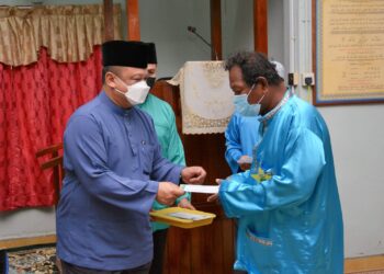 TUANKU Syed Faizuddin Putra Jamalullail (kiri) berkenan bagi menyampaikan sumbangan bantuan agihan zakat MAIPs kepada salah seorang penerima yang layak di Masjid Al-Hasyimi Kampung Long Boh, Arau, Perlis. -UTUSAN