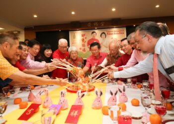 CHOW Kon Yeow (tengah) ketika menggaul 'yee sang' pada Majlis Rumah Terbuka Kadun Padang Kota di Lee Kongsi, George Town, Pulau Pinang hari ini.