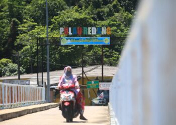 PENDUDUK menaiki motosikal di kawasan jeti di Kampung Pulau Redang di Kuala Nerus. - UTUSAN/PUQTRA HAIRRY ROSLI