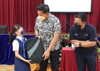 MOHD. SHAHAR Abdullah (tengah) bersama Darwis Abdul Razak menyampaikan sumbangan kit keselamatan dan barangan keperluan persekolahan kepada seorang pelajar di Program MESRA ECRL Pahang di UMP Gambang di Kuantan, Pahang.