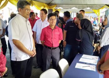 MARZUNISHAM Omar (dua kiri) bersama Mohd. Muazzam Mohamed (tiga kiri) bermesra dengan salah seorang peniaga pada pelancaran Program e-Duit Desa di Jeniang, Gurun.