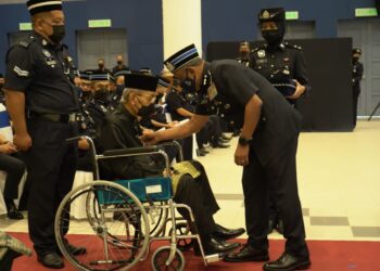 RAMLI Mohamed Yoosuf (kanan) menyampaikan Pingat Jasa Pahlawan Negara (PJPN) kepada bekas-bekas anggota polis di Kem PGA Bukit Galing, Kuantan, Pahang. - IHSAN POLIS PAHANG