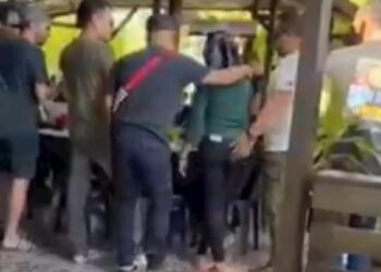 TANGKAP layar rakaman klip video memaparkan dua pelanggan lelaki memeluk bahu dan pinggang seorang wanita di sebuah kedai makan yang tular dalam media sosial sejak awal minggu ini. - MEDIA SOSIAL