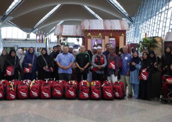 SEBAHAGIAN kumpulan trip khas pemulihan operasi umrah Emraz bergerak menaiki pesawat di Terminal 1, KLIA, Sepang, Selangor. - UTUSAN/AMREE AHMAD
