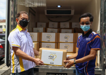 Paul Low (kiri) dan Muhammad Nizam Samsudin bersama barangan sumbangan.