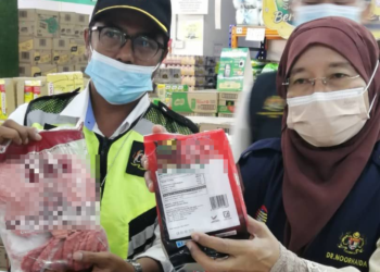 DR. Noorhaida Ujang menunjukkan makanan yang telah mencapai tarikh luput dalam serbuan Op Lak dan Sita yang diadakan di pasar raya di sekitar Muar. - UTUSAN/NUR ALINA HASSAN