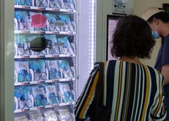 PENDUDUK Singapura boleh mendapatkan pelitup muka yang dijual di mesin layan diri dengan mengimbas kad pengenalan mereka.-AFP