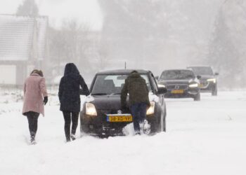 PENDUDUK menolak kereta yang tersekat akibat dilitupi salji tebal di Haarlem, berhampiran Amsterdam, Belanda. - AFP