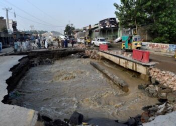 PENDUDUK melihat jalan raya yang berlubang akibat banjir di Khyber Pakhtunkhwa, Pakistan. - AFP