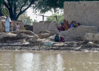 PENDUDUK menunggu di rumah mereka untuk diselamatkan pasukan keselamatan ketika banjir meningkat susulan hujan lebat berterusan di Rajanpur, Pakistan. - AFP