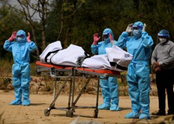 AHLI keluarga memakai baju perlindungan diri (PPE) melakukan solat jenazah sebelum mengebumikan pesakit Covid-19 yang meninggal dunia di New Delhi, India. - AFP