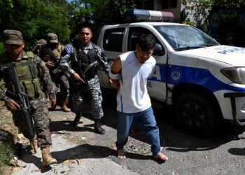 PASUKAN keselamatan menahan seorang lelaki yang disyaki terlibat kegiatan mafia di Soyapango, El Salvador kelmarin. - AFP