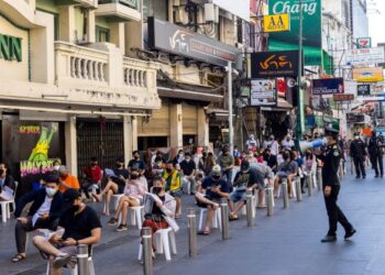 ORANG ramai duduk dalam barisan untuk melakukan ujian Covid-19 di Bangkok, Thailand. - AFP
