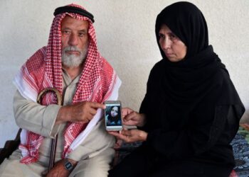 SULEIMAN (kanan) dan isterinya, Nazmiya Baraka (kiri) menunjukkan gambar anak mereka, Istabraq yang dibunuh oleh suaminya setahun lalu. - AFP