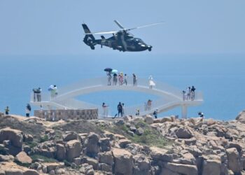 ORANG ramai melihat helikopter tentera China terbang di Pulau Pingtan di wilayah Fujian yang berhampiran Taiwan. - AFP