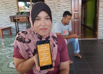 Zaiton Mat Rashid menunjukkan status yang dimuat naik ibu saudaranya, Allahyarham Zainab Ahmad yang maut dalam kemalangan di Sungai Bakap, Pulau Pinang kelmarin.