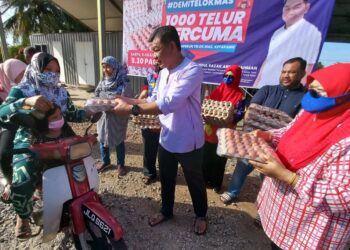 ABDUL RAZAK Abdul Rahman mengagihkan telur kepada orang ramai di DUN Telok Mas, Melaka. - UTUSAN/AMRAN MULUP