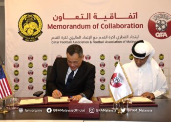 Presiden FAM, Datuk Hamidin Mohd Amin (kiri) menandatangani MoU dengan Persatuan Bolasepak Qatar (QFA).-IHSAN FAM