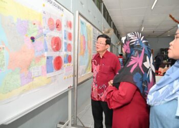 CHOW Kon Yeow mendengar penerangan daripada pegawai JPV ketika meninjau Pusat Operasi ASF di Valdor, Nibong Tebal, Pulau Pinang hari ini.