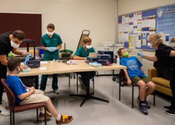DUA kanak-kanak menjalani ujian calitan Covid-19 di Sekolah Rendah Brandeis di Kentucky.-AFP