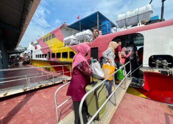 PENUMPANG menaiki feri yang menghubungkan Pulau Langkawi dengan Kuala Kedah dan Kuala Perlis di Terminal Feri Kuah, Langkawi.