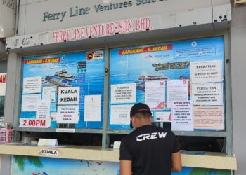PENYEDIA perkhidmatan feri ke Langkawi mula menampal notis yang memerlukan orang ramai menunjukkan kad pengenalan untuk membeli tiket feri di Kuala Kedah, semalam. - UTUSAN/NUR AMALINA AZMAN