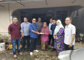 HARIS SALLEH Hamzah menyampaikan sumbangan kepada Kamariah Abd. Samad di Taman Rumah Kos Rendah peringkat 3 di Jerantut, Pahang. - UTUSAN/SALEHUDIN MAT RASAD