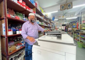 HABIBULLAH E.M PAKIR MOHAMEED memeriksa mesin fotostat sejurus selepas membuka kedai bukunya di Jalan Hospital, Kangar, Perlis, semalam.  
 - UTUSAN/NAZLINA NADZARI