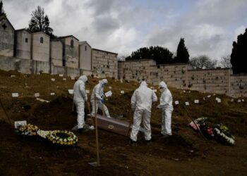 Penggali kubur lengkap memakai PPE menanam mayat mangsa Covid-19 di Alto de Sao Joao di Lisbon, Portugal, baru-baru ini