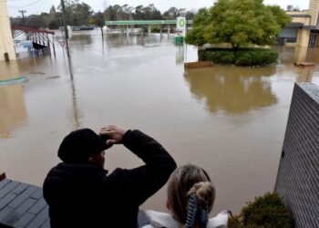 PENDUDUK melihat kawasan persekitaran yang dilanda banjir akibat hujan lebat di Camden, Sydney.-AFP