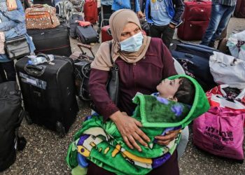 SEORANG wanita Palestin dan anaknya menunggu giliran untuk masuk ke Mesir menerusi lintasan Rafah bagi mendapatkan rawatan perubatan. - AFP