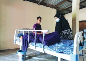 NIK Noradila menguruskan ibunya yang menghidap penyakit saraf sejak lima bulan lalu di Kampung Salak, Tanah Merah. - UTUSAN/ROSALWANI CHE SOH