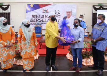SULAIMAN Md. Ali menyampaikan sumbang sempena sambutan Deepavali sambil diperhatikan M.S. Mahadevan (kanan) di Seri Bendahara, Ayer Keroh, Melaka. 